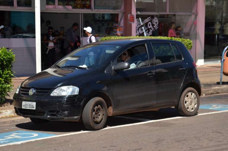 Motorista estaciona em vaga exclusiva, ao mesmo tempo que fala ao celular (Foto: Vanderlei Aparecido)