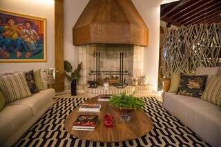 O ponto alto da sala de estar é a lareira que também funciona como churrasqueira a lenha. (Foto: Fernando Antunes)