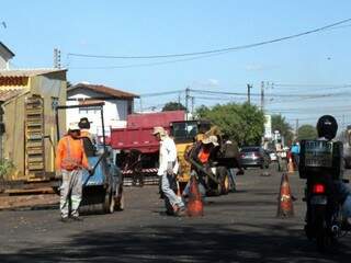 Homens trabalham no serviço de tapa-buraco, em Campo Grande. (Foto: Saul Schramm/Arquivo).