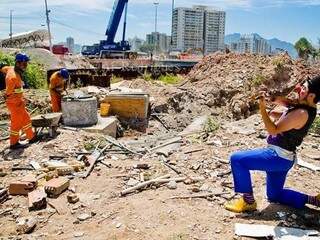 A última tentativa para sensibilizar os funcionários que ajudam na demolição da Vila Olímpica, foi por meio da música. (Foto: Elisângela Leite)