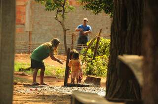 Crianças se molham na mangueira, no pátio da escola, na aldeia Arroio-Korá.