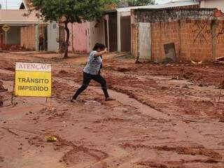 Zuleide Luiza não consegue evitar que o pé &quot;mergulhe&quot; em uma poça de lama. &quot;Não tem problema, se é para melhoria do bairro&quot;. (Foto: André Bittar)