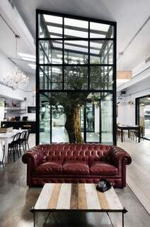 O Nook Osteria &amp; Pizzeria é um restaurante italiano que combina o chame italiano do velho mundo com a arquitetura moderna. A árvore é isolada em uma espécie de aquário com um teto de vidro. Quem assina o projeto é o escritório Noses Architects.