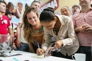 Marina Silva autografa livro em meio a ação de campanha: candidata avança nas pesquisas. (Foto: Divulgação)