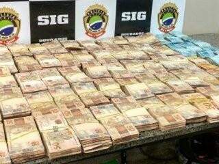 &quot;Bolos&quot; de dinheiro foram encontrados escondidos em carro, usado por dupla que traficava drogas. (Foto: Dourados News)
