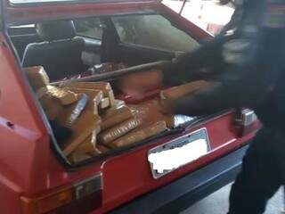 Policial retirando os tabletes de maconha de dentro do carro. (Foto: Divulgação) 
