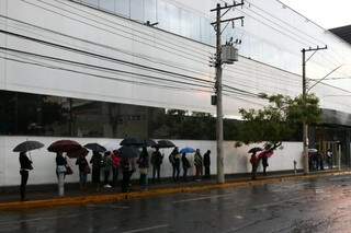 Fotos enviadas à redação do Campo Grande News mostram os passageiros em fila, com guarda-chuvas nas mãos. (Foto: Bruna Kaspary)
