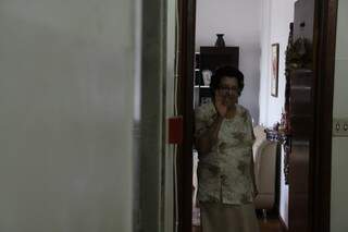 Na porta de casa, Ana, que brinca que está no asilo Dona Neta.
