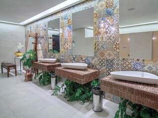 Banheiro coletivo com azulejos que imitam ladrilho.