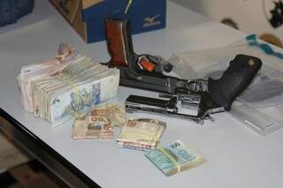 Parte do dinheiro recuperado pela polícia e armas usadas em crime (Foto: Cleber Gellio)