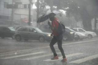 Pedestre tenta se proteger com guarda-chuva (Foto: Marcos Ermínio).