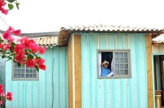 Seu Orlando, acena da janela da casa de madeira, dos colonos. (Foto: Alcides Neto)
