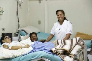 Sorridente, enfermeira Tânia distribui alegria aos quartos de todos os pacientes.