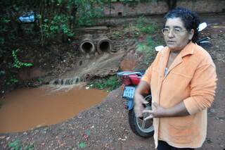 A moradora Eurides Soares próxima às tubulações que desembocam na cratera. (Foto: João Garrigó)