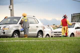 Os palhaços param os carros para vender brinquedos e pedir dinheiro para os motoristas (Foto: Marcos Ermínio)