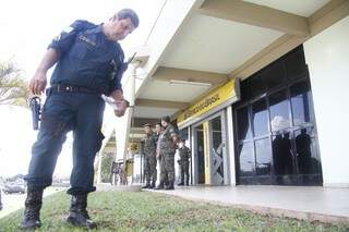 Policial procura projétil de bala que atingiu um cliente durante tentativa de assalto. (Foto: Marcelo Victor) 