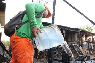 Morador usou balde de água para apagar as chamas que começaram por volta das 10h de hoje (Foto: Marcos Ermínio)