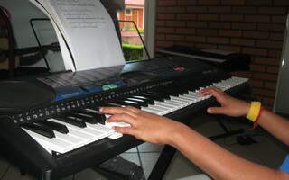 Everton tocando teclado no Lar das Crianças. Adolescente aprendeu ter o gosto pela música com o padrinho. (Foto: Paula Vitorino)