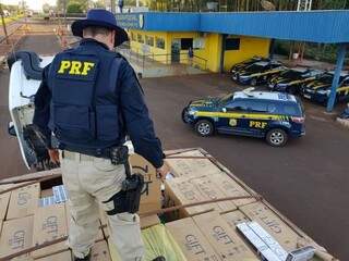 Agente da Polícia Rodoviária Federal sobre carga de cigarros apreendida em MS. (Foto: Arquivo) 