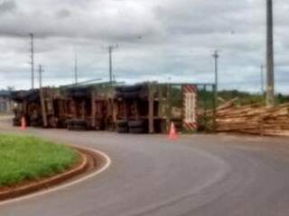 Caminhão carregado com madeira tomba às margens de rodovia (Foto: Direto das Ruas)