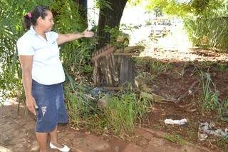 A copeira mostra indignada o abandono do terreno baldio ao lado.