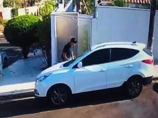 De boné e camiseta preta, ladrão antes de quebrar o vidro do carro de funcionária pública. (Foto: Reprodução vídeo)