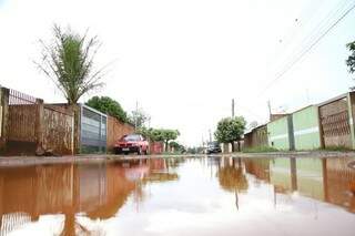 Rua Galeão, no bairro Aero Rancho, ficou alagada. (Foto: Henrique Kawaminami)