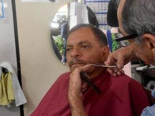 À moda antiga, Toninho só finaliza o corte após aparar o bigode e a sobrancelha de seus clientes. (Foto: Roberto Higa)