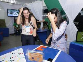 Anielly (à esquerda) e amiga comemoram resolução de quebra-cabeças no Museu Itinerante da UFMG (Foto: Kísie Ainoã)