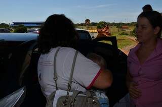 Bebê no colo da conselheira sendo colocado dentro do carro. (Foto: Vanderlei Aparecido)
