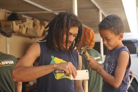 Crianças e adultos aprendem a fabricar berimbau com madeira do cerrado