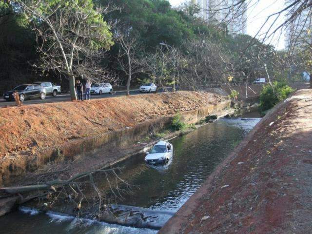 Jovem perde controle de ve&iacute;culo, bate em &aacute;rvore e cai em c&oacute;rrego