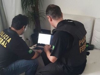 Agentes fazem varredura em computador apreendido na casa de um dos três detidos pela operação (Foto: Divulgação/PF)