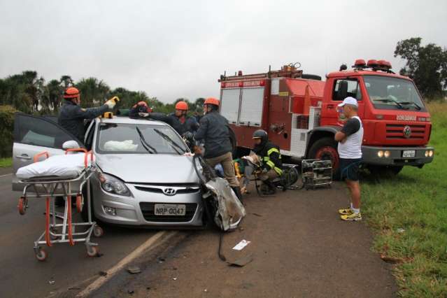 Motorista fica preso em carro ap&oacute;s colidir com carreta com 17t de milho