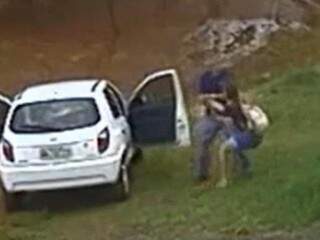 Suspeito levando menina a força para o veículo (Foto: Reprodução)