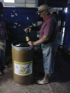 Morador depositando óleo de cozinha no tonel de coleta do Ecoponto.(Foto:Divulgação)