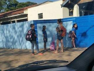 Alunos de uma escola da área central de Dourados esperando abertura de portão às 8h de hoje (Foto: Direto das Ruas)