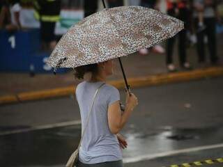Mulher de guarda-chuva na avenida Afonso Pena (Foto: Marcos Ermínio)