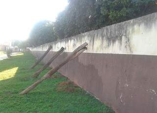 Segundo diretora, estacas foram colocadas por técnicos da Secretária de Obras para sustentar muro até o reparo (Foto: Coxim Agora)