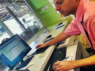 Trabalhador de empresa emitindo bilhete eletrônico (Foto: Divulgação)