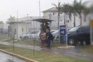 Moradores se protegem da chuva em ponto de ônibus&gt;