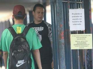 Alunos sendo recebidos na Escola Estadual Joaquim Murtinho, onde aviso sobre greve foi afixado no portão (Foto: Saul Schramm)
