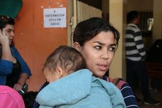 Com o filho no colo, Gisele pegou dois ônibus para chegar ao posto, mas não conseguiu a vacina (Foto: Fernando Antunes)