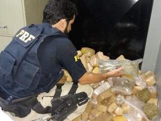 Policial quantificando as drogas encontradas no veículo. (Foto: PRF) 