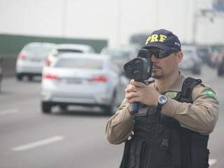 Policial monitorando a velocidade de veículos em rodovia. (Foto: Divulgação/PRF/ReproduçãoAgênciaBrasil) 
