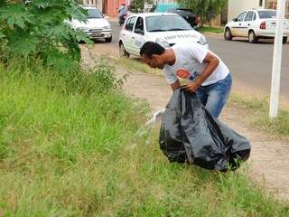 Vereador Coringa recolhe lixo em ação de combate à dengue no Tiradentes. (Foto: Rodrigo Pazinato)
