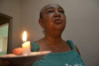 Sem energia, dona Marisa teve de espalhar velas pela casa. (Foto: Minamar Junior)