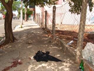 Na calçada ainda estão as marcas de sangue e acamiseta do segurança. (Foto: Simão Nogueira)