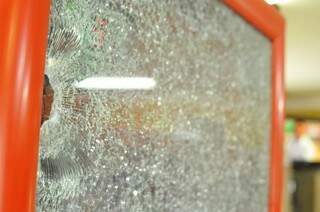 Vidro atingido por tiros durante o roubo à padaria (Foto: Alcides Neto)