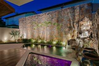 Cascata dá para piscina e revestimento de parede segue a rusticidade das pedras. (Foto: Fellipe Lima)